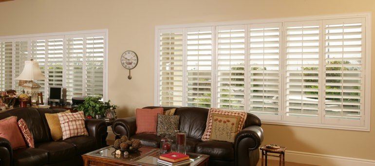 Wide window with white shutters in Southern California living room